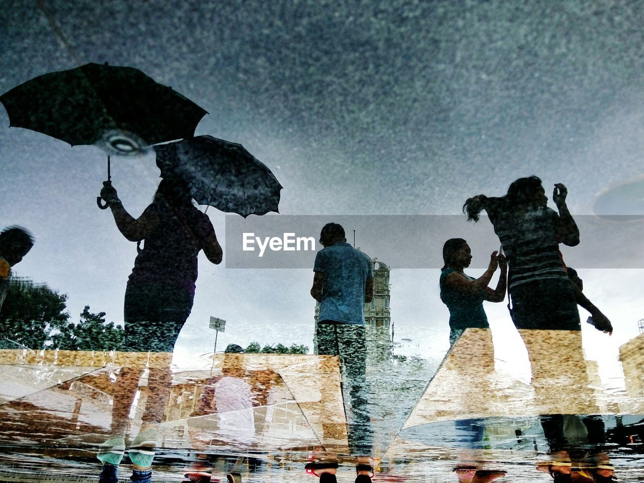 HIGH ANGLE VIEW OF PEOPLE ON WET GLASS