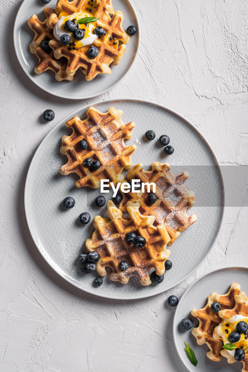 Breakfast with waffles with blueberries and syrup on a plates