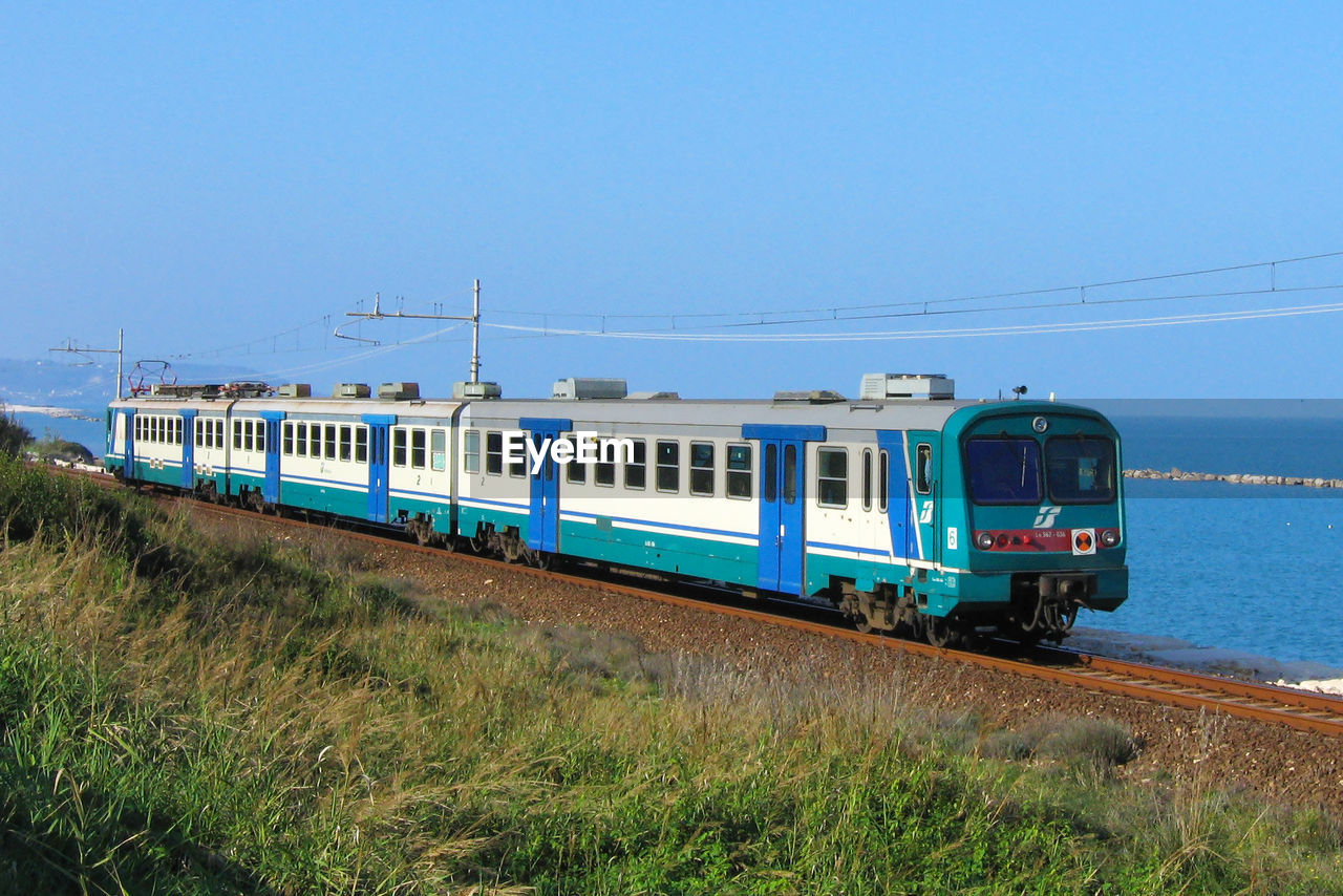 TRAIN ON RAILROAD TRACKS AGAINST SKY