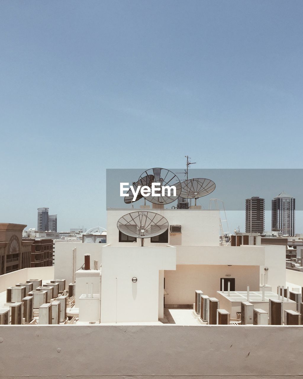 Satellite dishes on building terrace in city