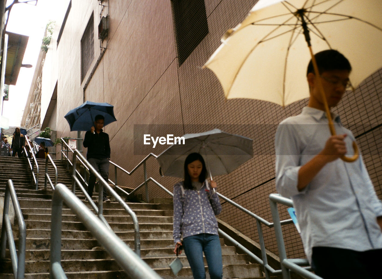 PEOPLE STANDING ON STAIRCASE AT BUILDING