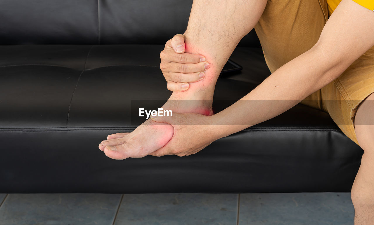 LOW SECTION OF WOMAN SITTING ON FLOOR