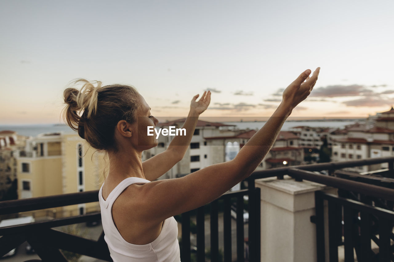 Serene woman enjoying the sunset on roof terrace