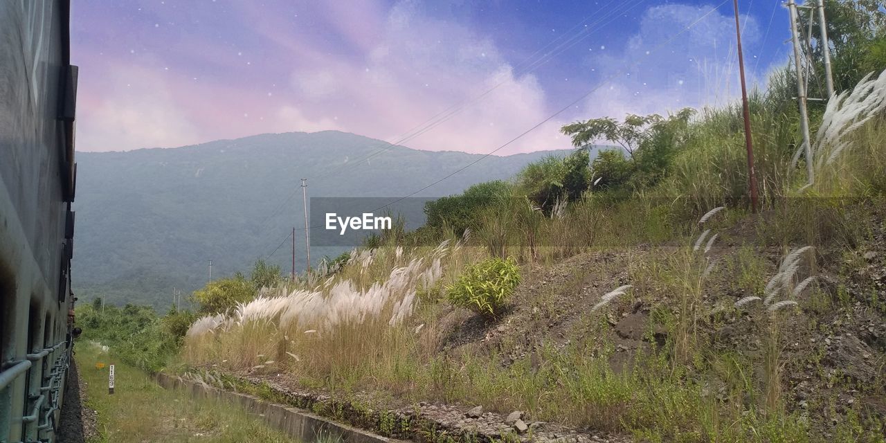 PANORAMIC SHOT OF LAND AND MOUNTAINS AGAINST SKY