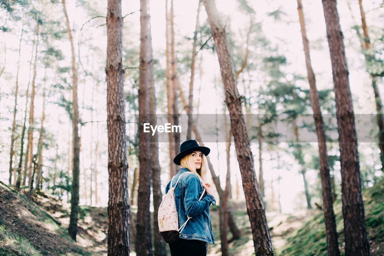 WOMAN STANDING IN FOREST