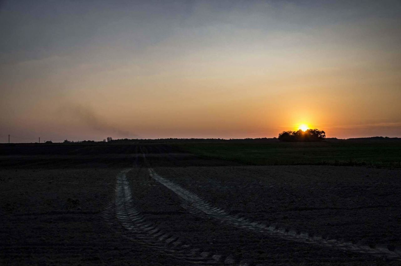 AGRICULTURAL FIELD AGAINST SKY DURING SUNSET