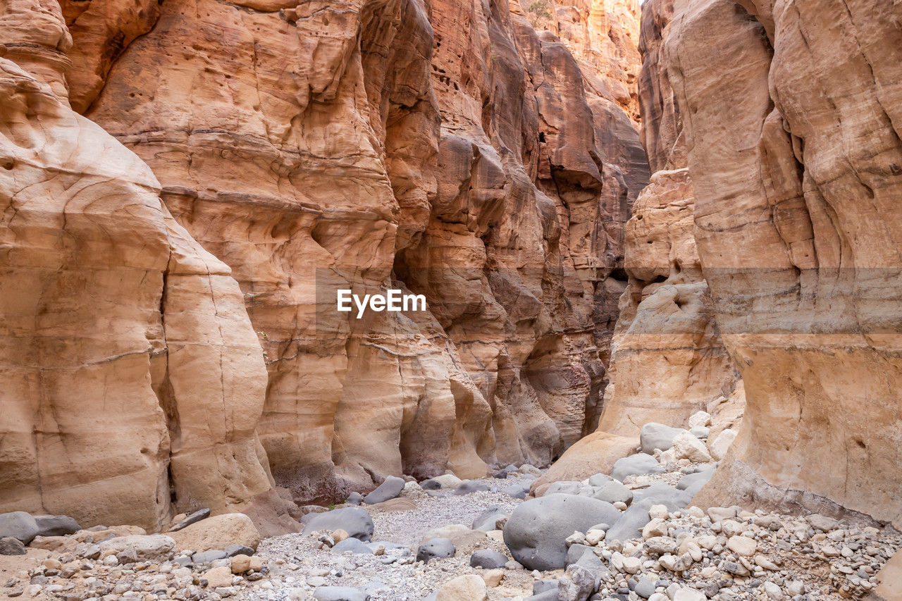 rock, rock formation, wadi, geology, non-urban scene, nature, no people, eroded, physical geography, travel destinations, scenics - nature, beauty in nature, land, environment, desert, travel, landscape, extreme terrain, climate, canyon, arch, tranquility, day, ancient history, formation, outdoors, valley, cliff, sandstone, arid climate, dry, sunlight, terrain, tranquil scene, pattern, brown