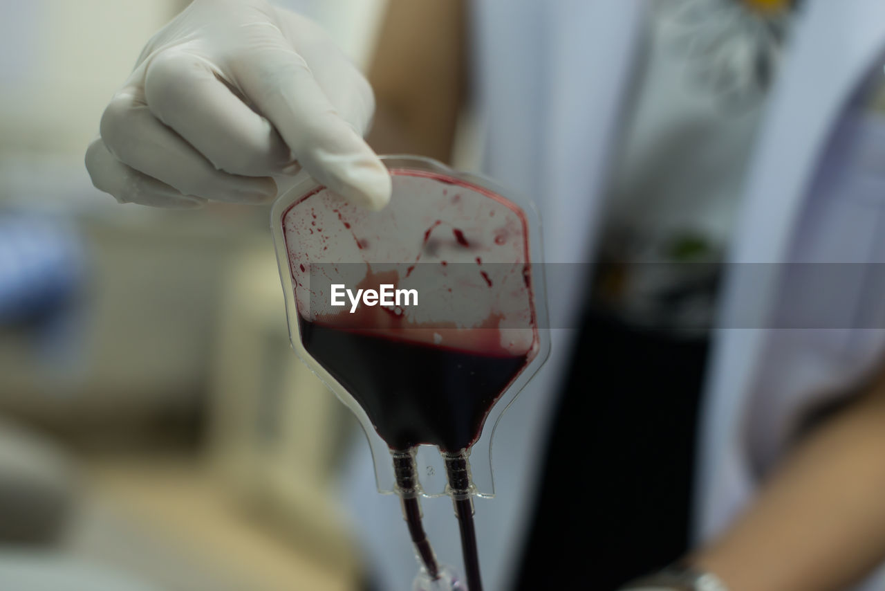 Midsection of doctor holding blood samples at hospital