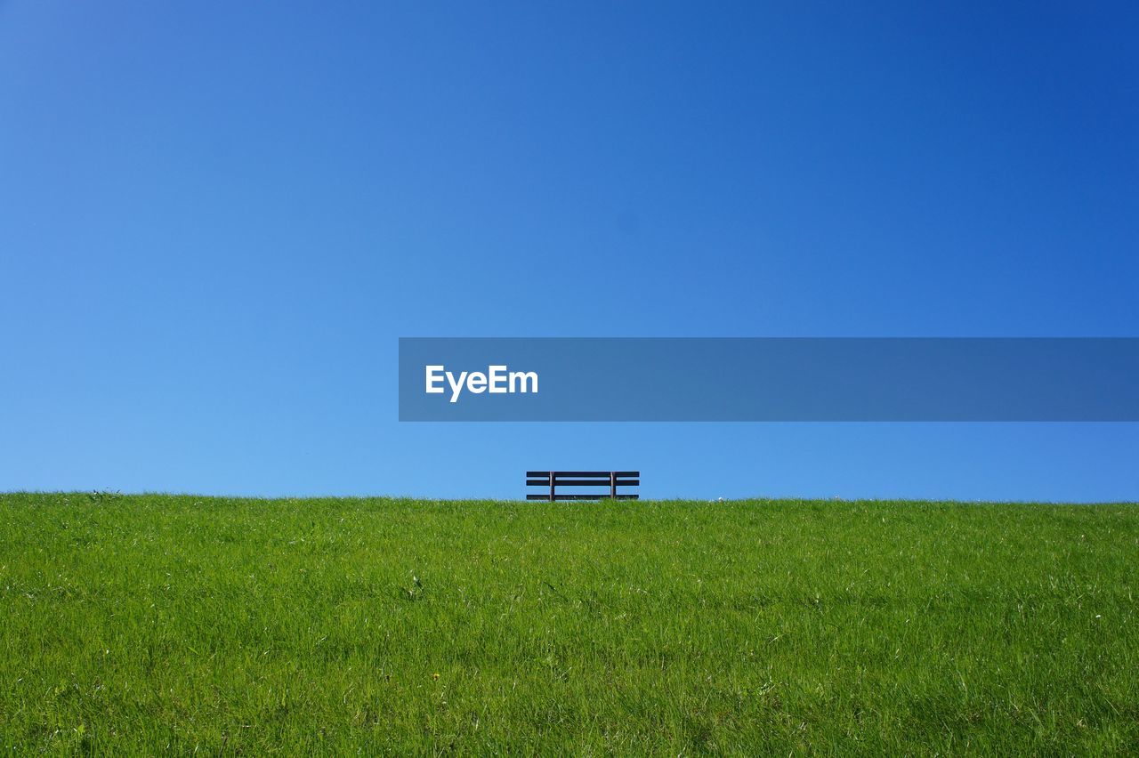 Scenic view of field against clear blue sky