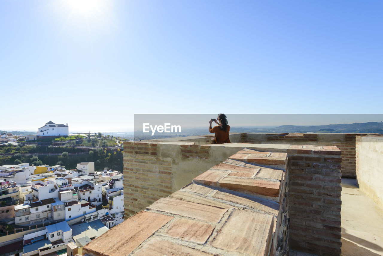 Woman taking photos from the alcazaba of velez malaga, malaga, s