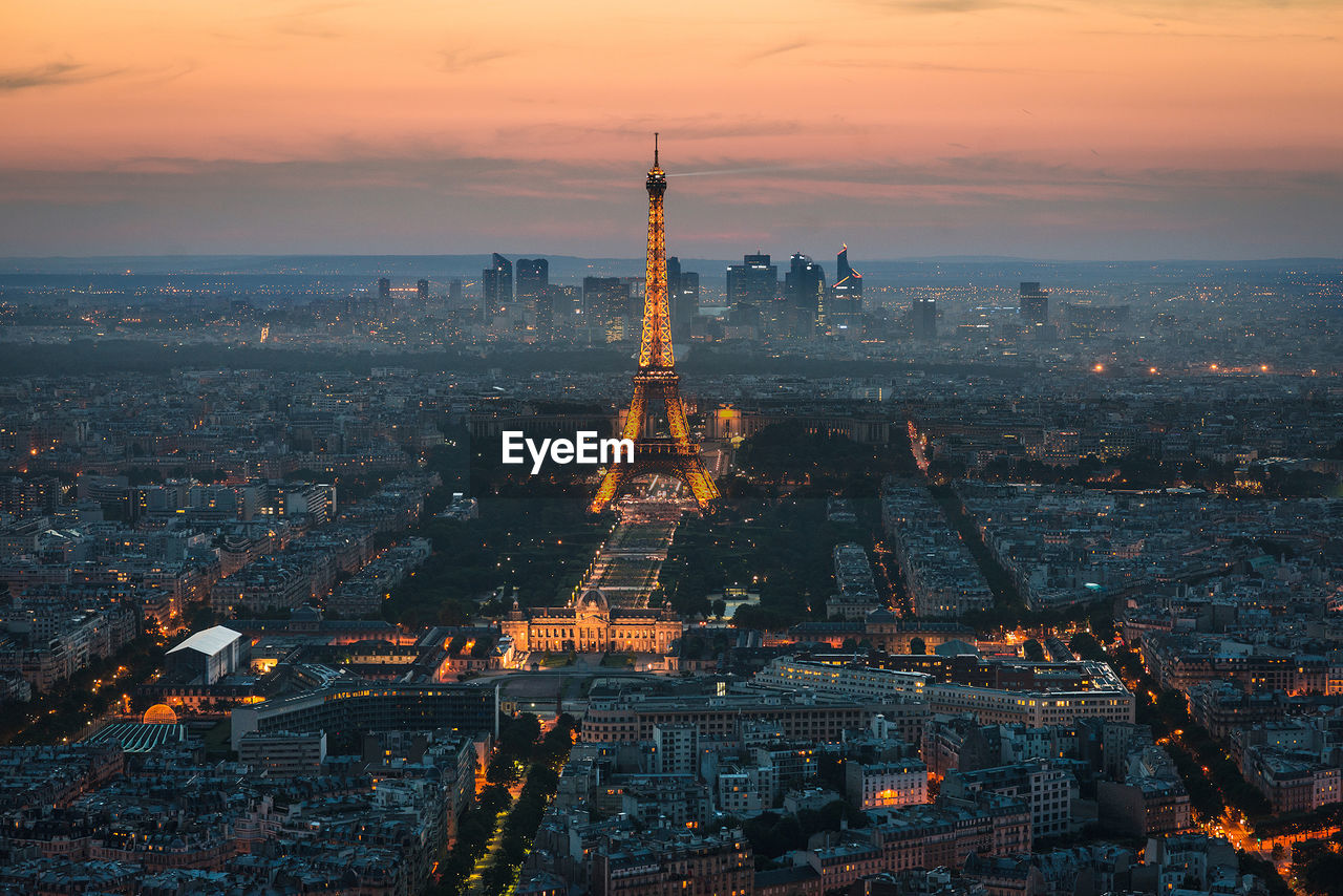 High angle view of cityscape with illuminated eiffel tower during sunset