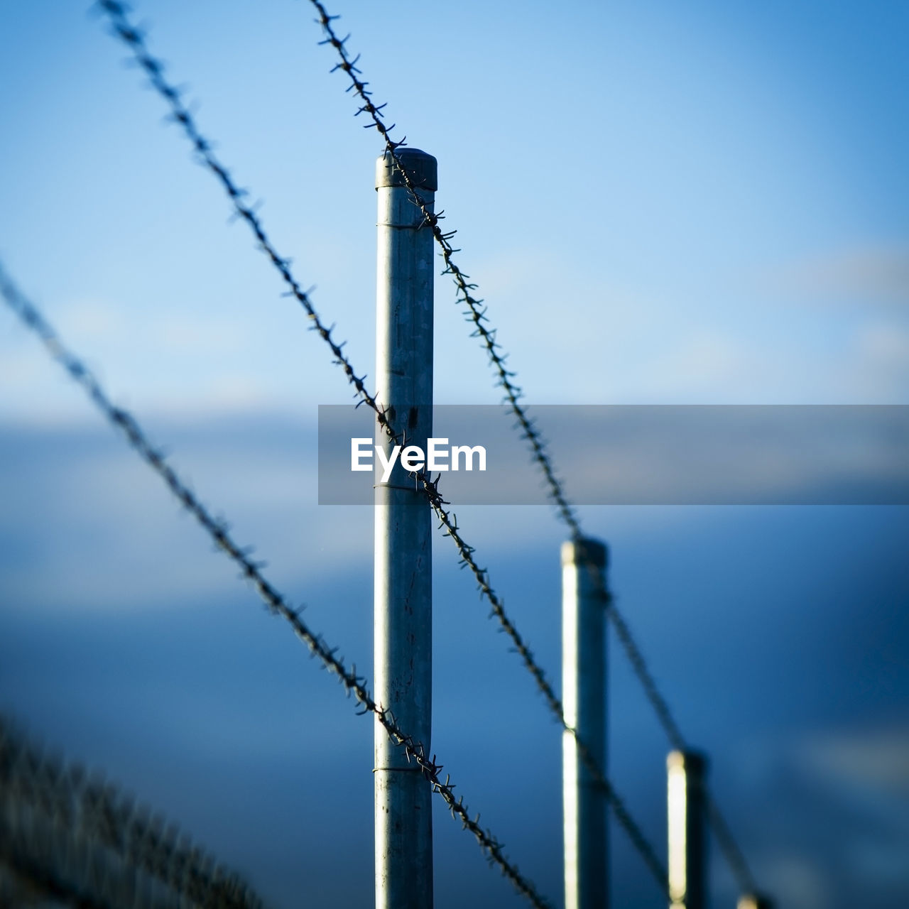 LOW ANGLE VIEW OF BARBED WIRE AGAINST SKY