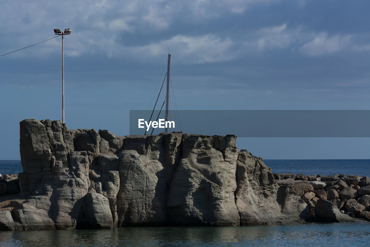 water, sea, sky, rock, coast, nature, cloud, beauty in nature, ocean, land, beach, scenics - nature, vehicle, bay, cliff, horizon over water, nautical vessel, sailboat, tranquility, tranquil scene, no people, rock formation, transportation, horizon, waterfront, outdoors, shore, day, coastline, breakwater, idyllic, tower, terrain, architecture, travel, travel destinations, non-urban scene, blue, environment