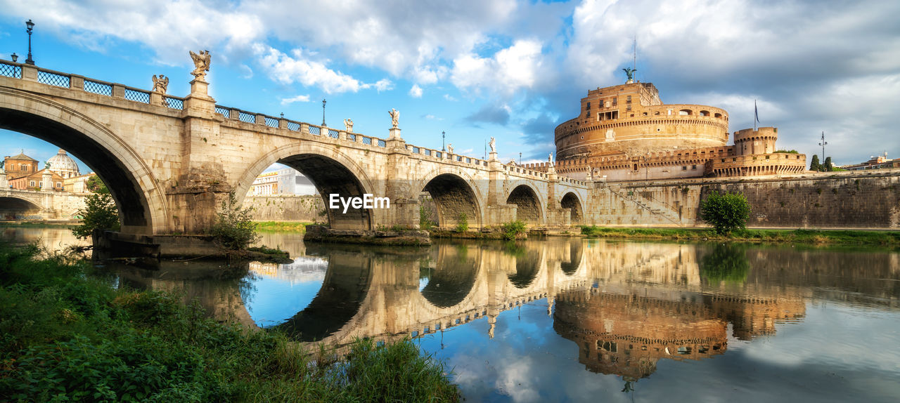 Arch bridge over river against sky