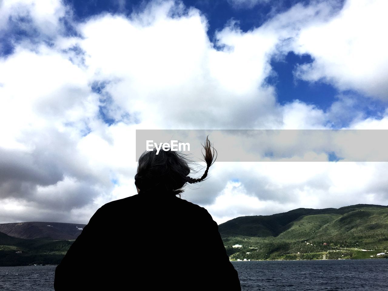 REAR VIEW OF MAN LOOKING AT LAKE AGAINST MOUNTAINS