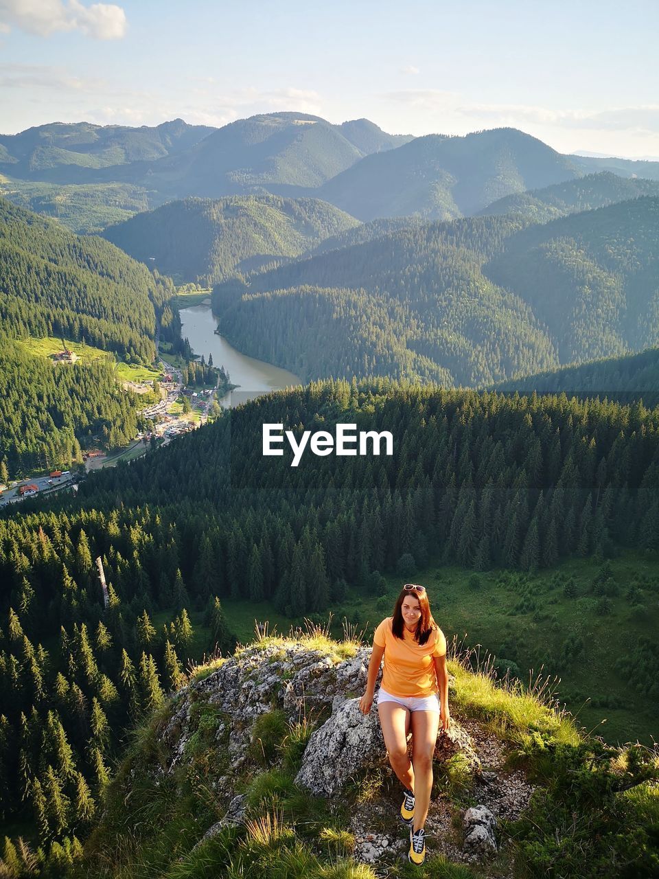 High angle view of woman sitting on rock against landscape