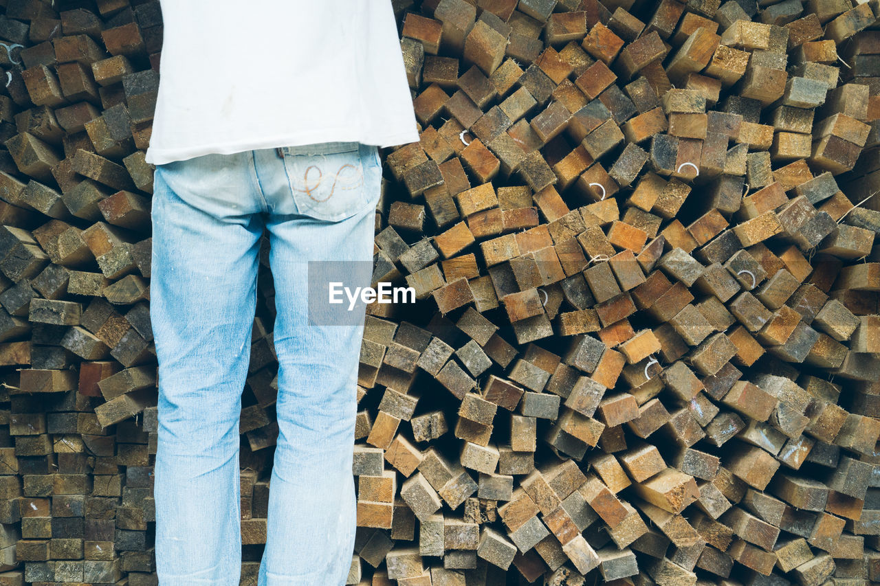 Person standing by wood stack