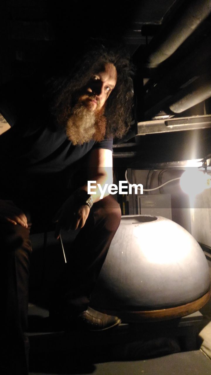 MAN LOOKING AT ILLUMINATED LAMP