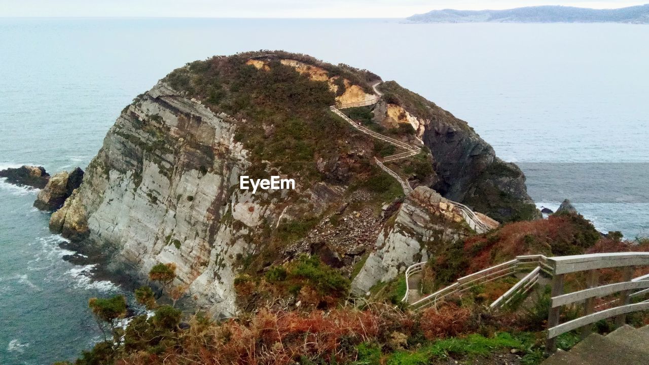 HIGH ANGLE VIEW OF ROCK FORMATION IN SEA AGAINST SKY