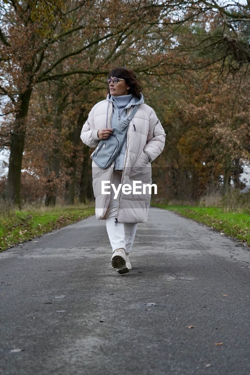 Portrait of young woman standing on road