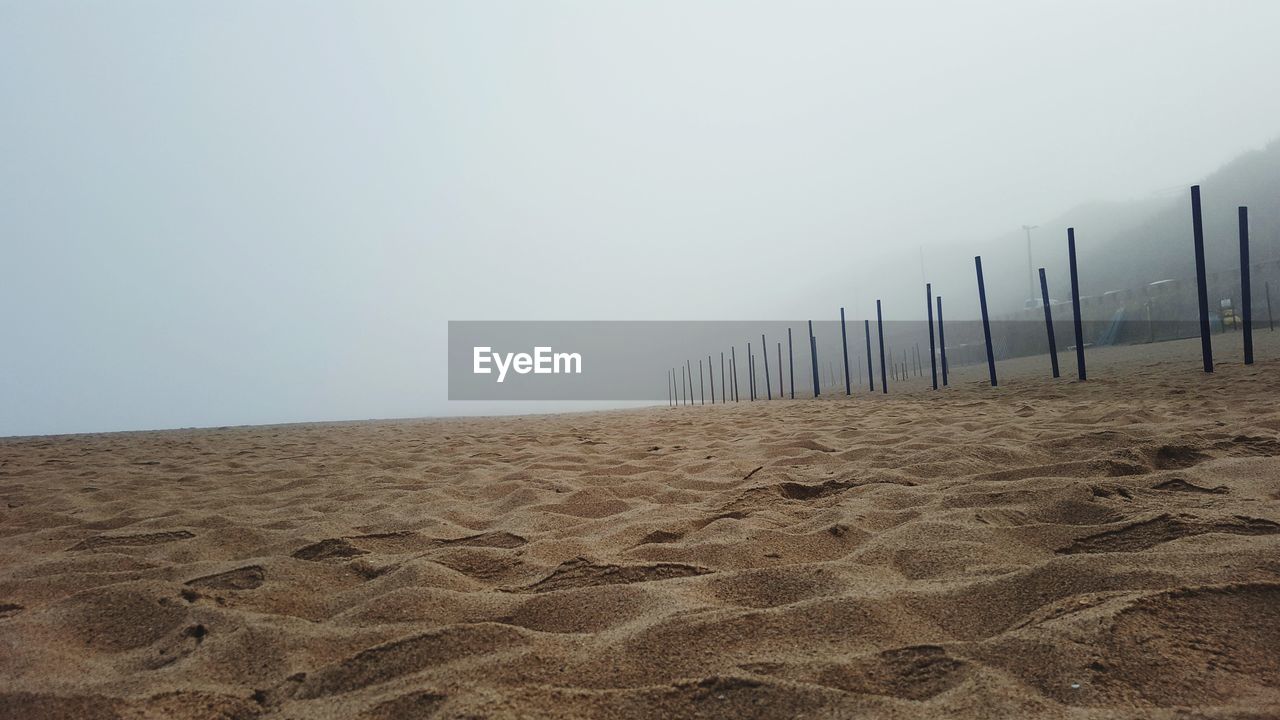 SAND ON BEACH AGAINST CLEAR SKY