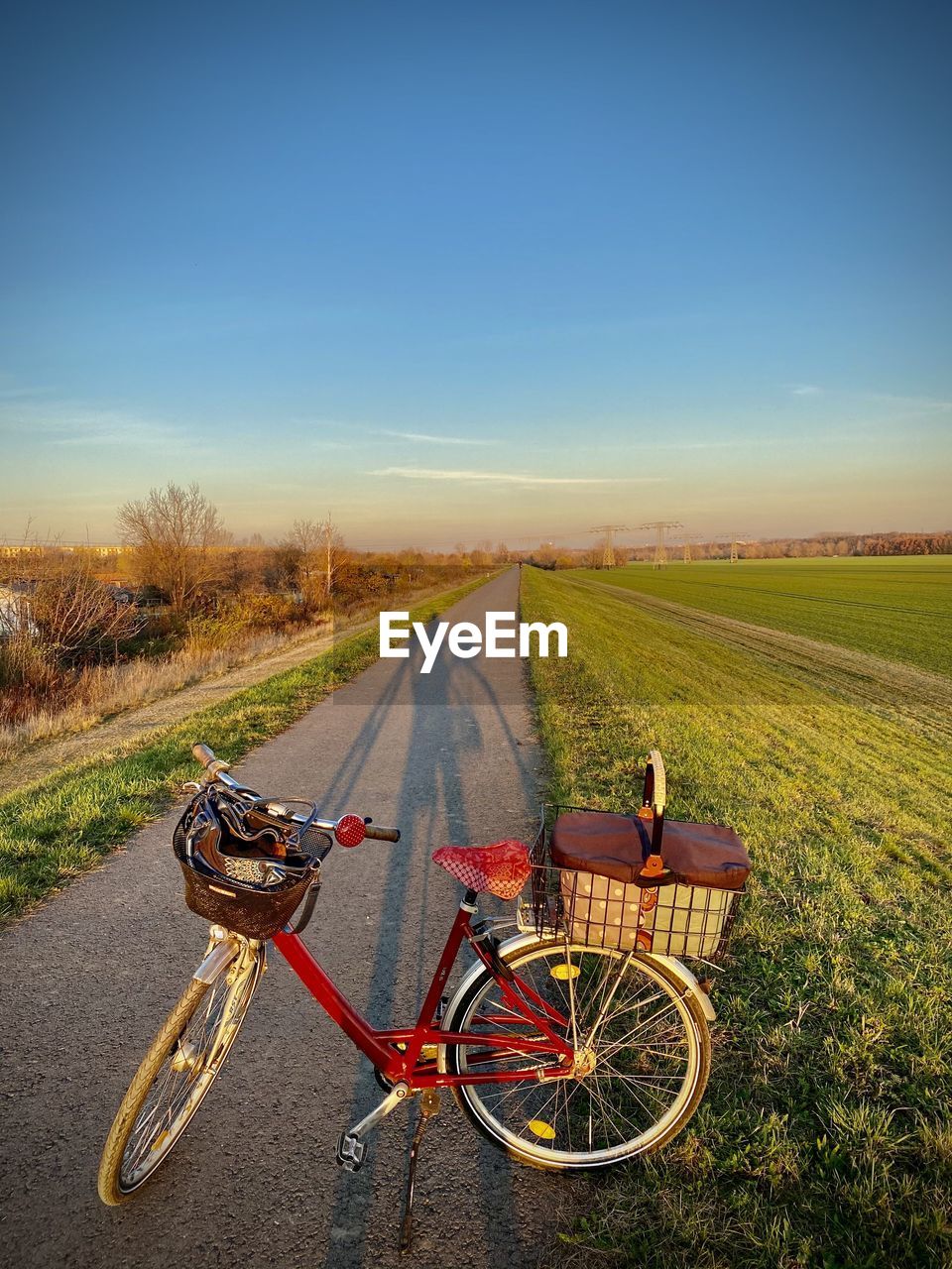 BICYCLE PARKED ON ROAD AMIDST FIELD