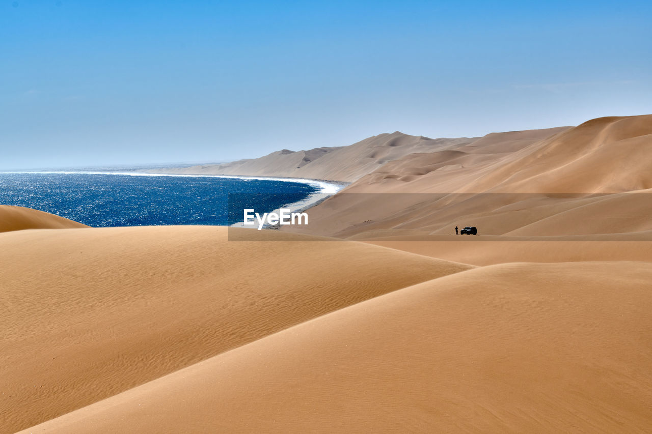 SAND DUNES IN DESERT AGAINST SKY