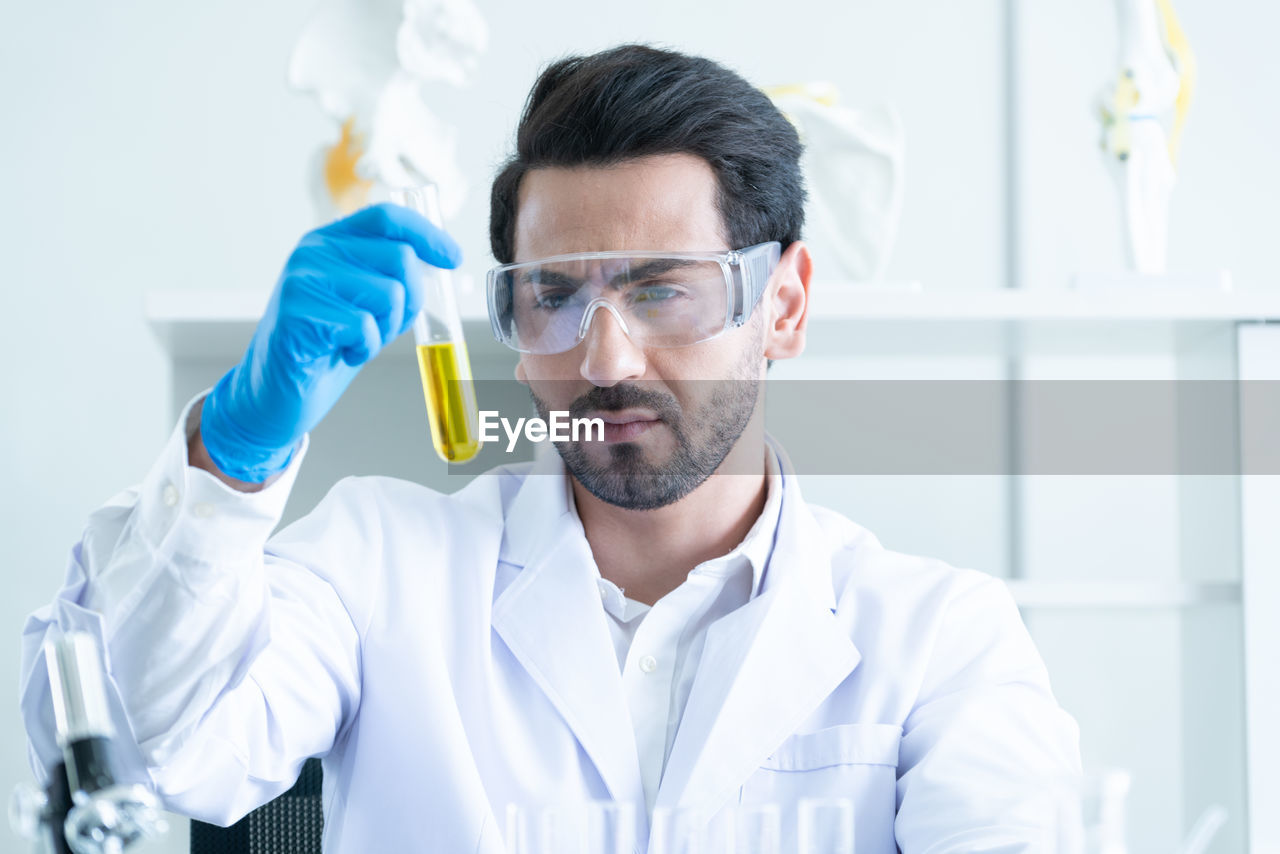 portrait of scientist holding dentures while standing in laboratory