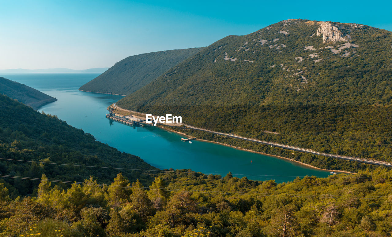 High angle view of lake and mountains against sky