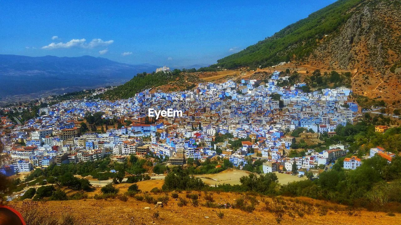 SCENIC VIEW OF TOWN AGAINST MOUNTAINS