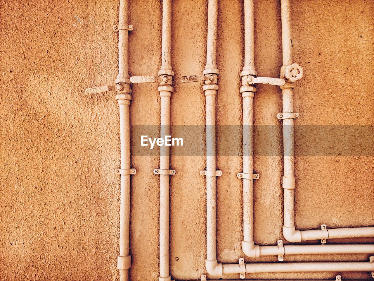 Pipes on brown wall