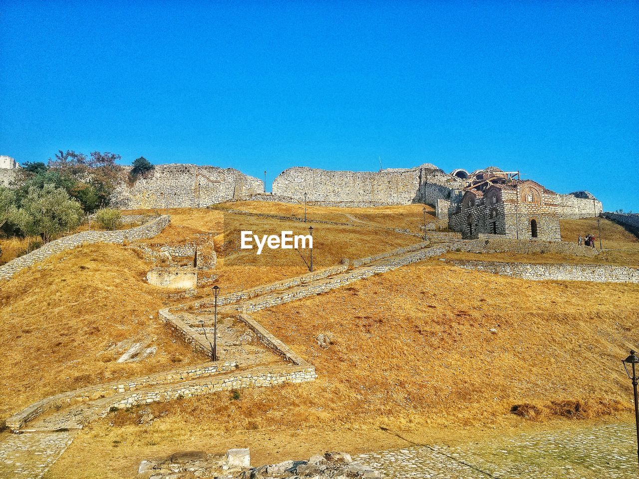 Low angle view of berat castle against clear blue sky