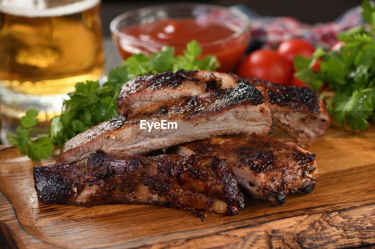 food and drink, food, meat, dish, steak, freshness, vegetable, meal, herb, roasting, healthy eating, dinner, table, no people, grilling, roasted, alcohol, red meat, rib eye steak, grilled, barbecue, indoors, cuisine, wood, close-up, beef, refreshment, still life, drink, cutting board, produce
