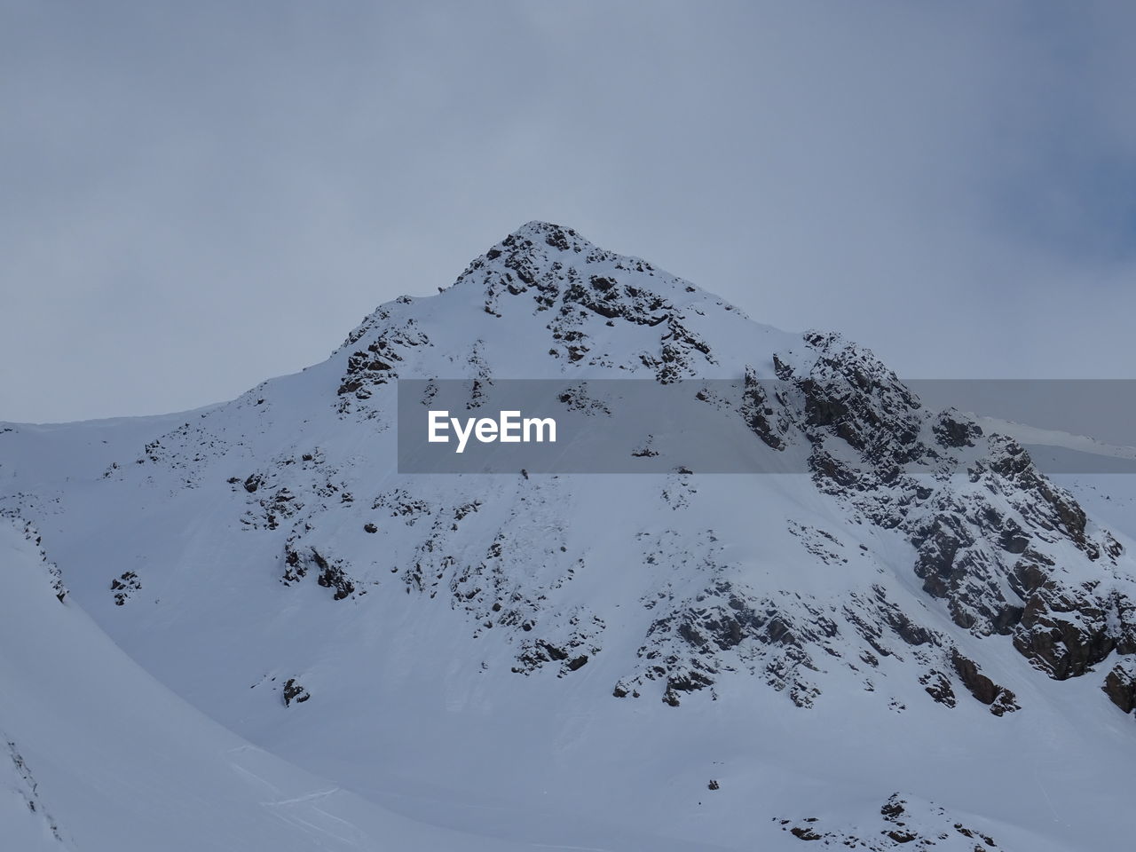 FLOCK OF SNOW COVERED MOUNTAIN AGAINST SKY