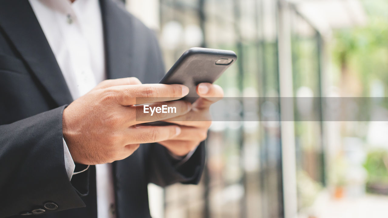midsection of businessman using phone
