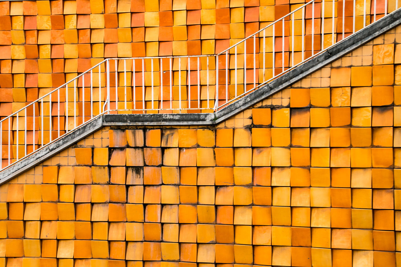 FULL FRAME SHOT OF STEPS AND YELLOW BRICK WALL