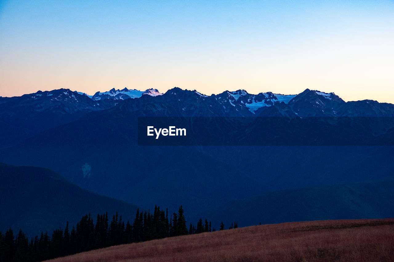 Scenic view of snowcapped mountains against clear blue sky