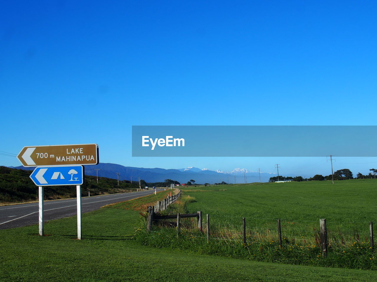 ROAD SIGNS ON FIELD AGAINST CLEAR SKY