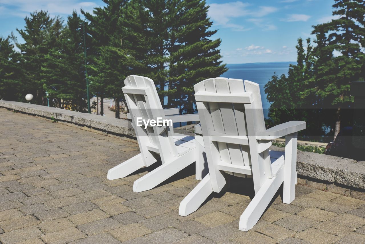 Chairs on tree against sky