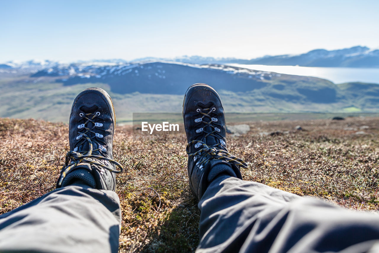 Low section of man relaxing on mountain