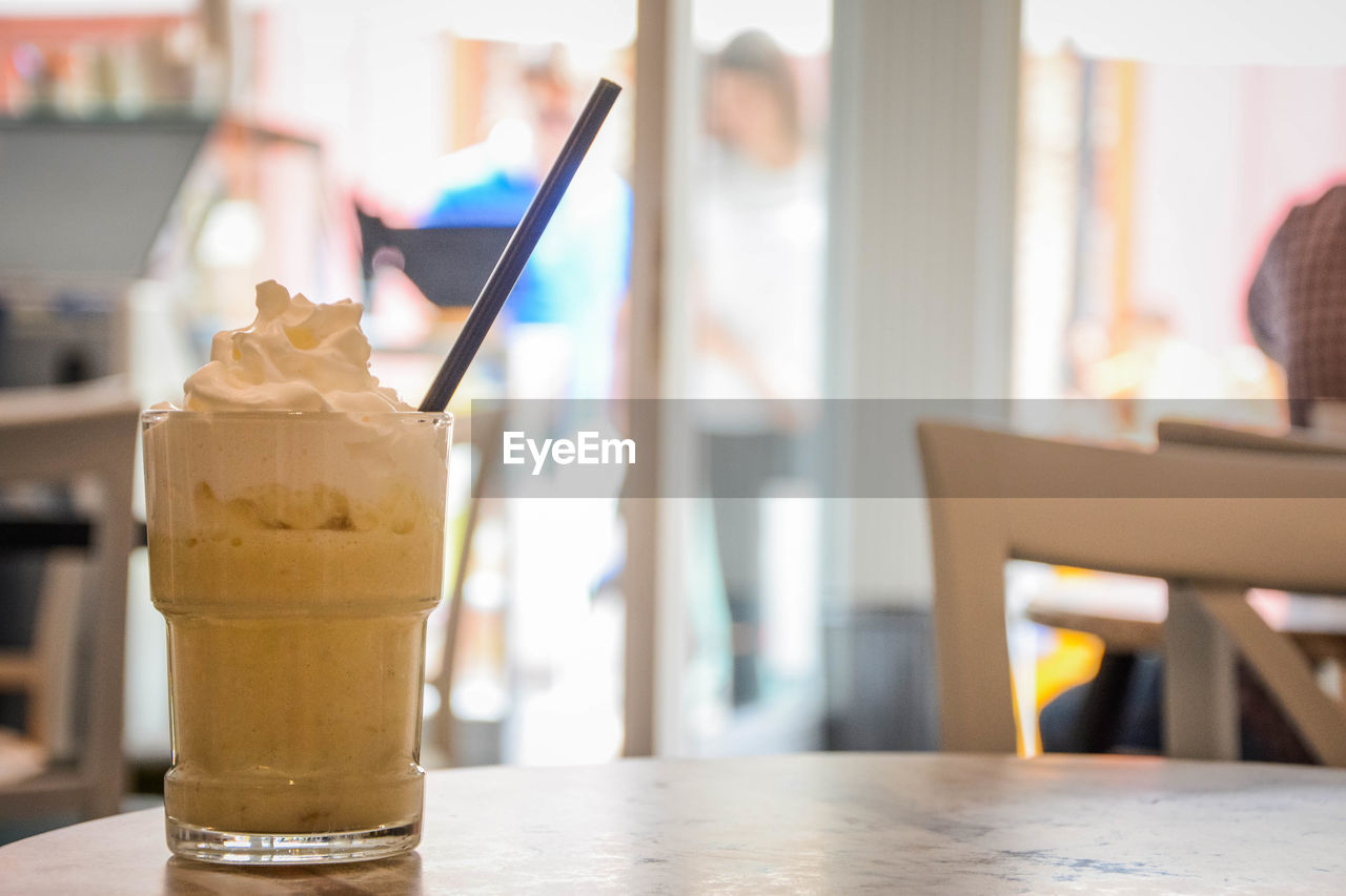 CLOSE-UP OF ICE CREAM WITH DRINK ON TABLE