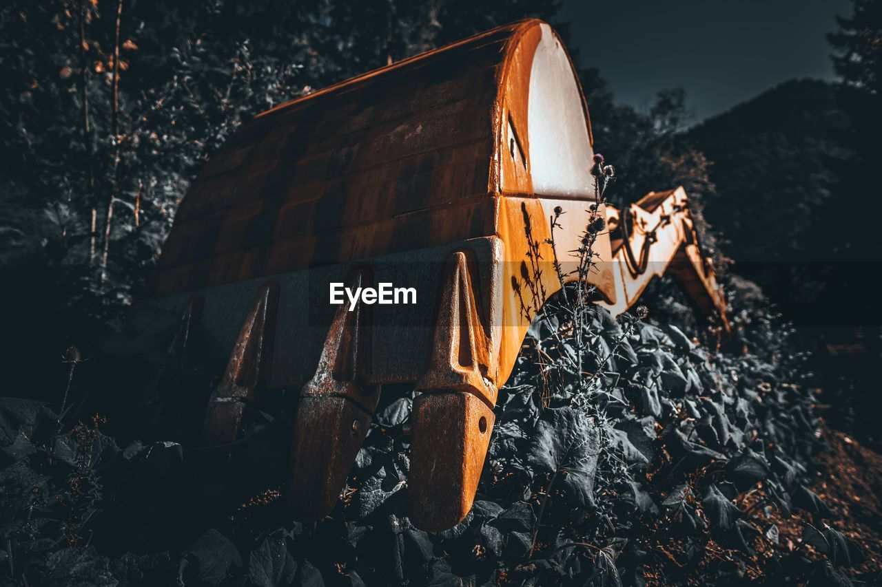 Wooden structure on field against trees at night