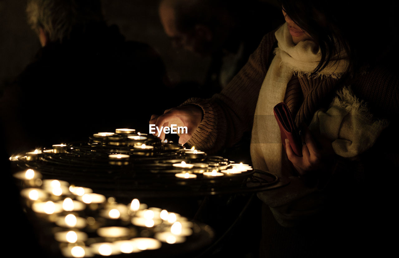 People lighting candles