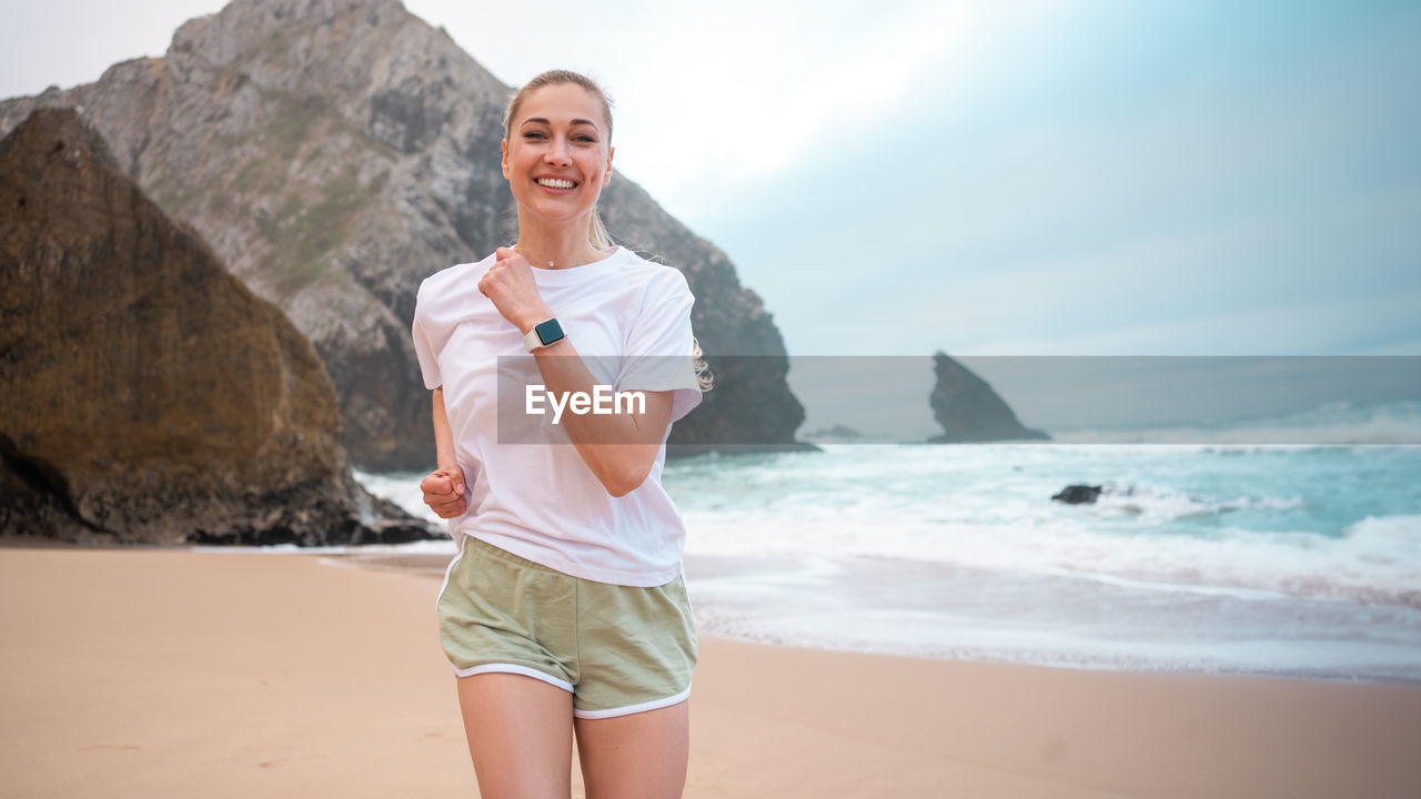 portrait of young woman standing on beach