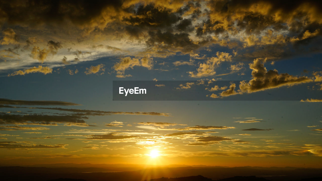 SCENIC VIEW OF DRAMATIC SKY OVER SILHOUETTE LANDSCAPE