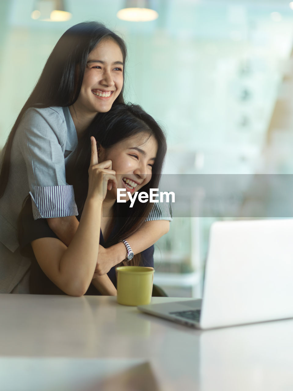 Smiling businesswomen using laptop at office