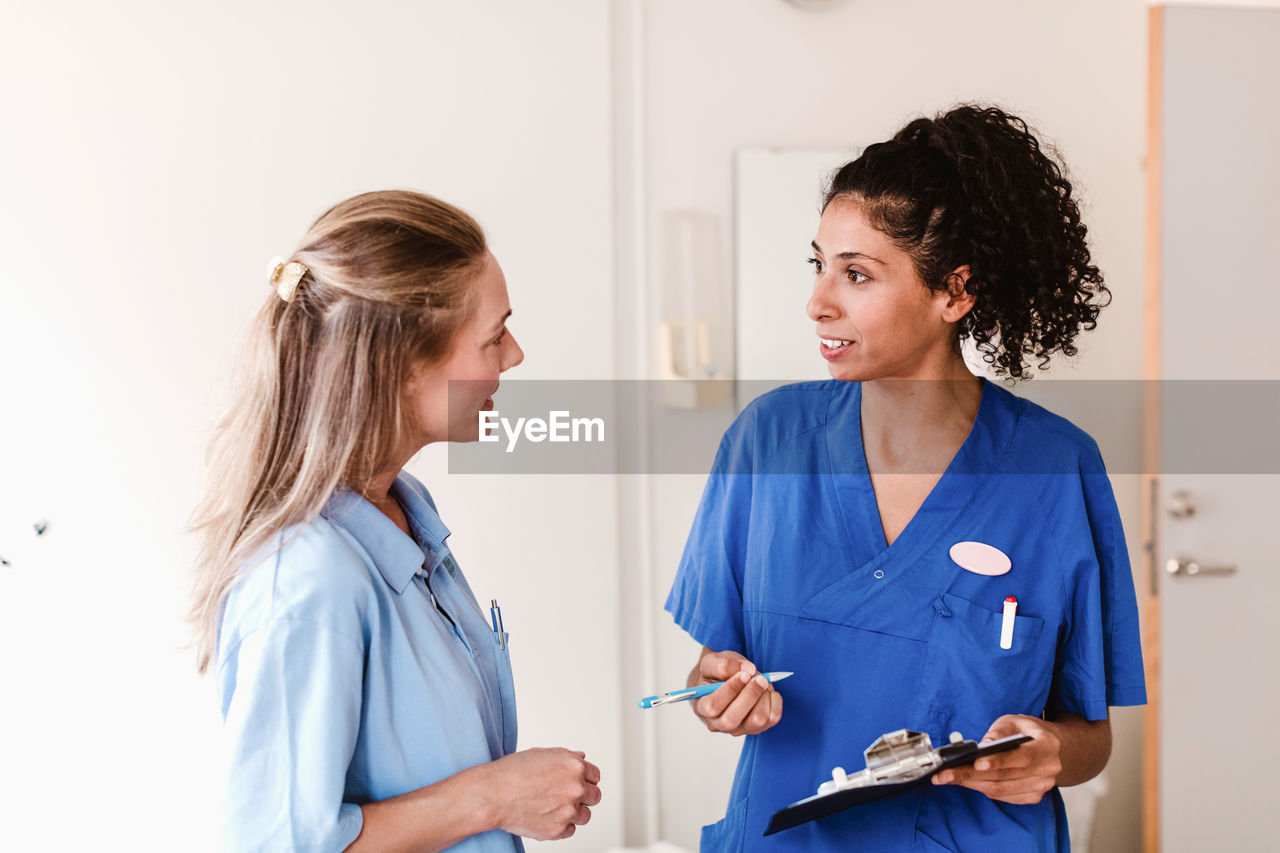 Female nurse discussing with doctor about medical report in hospital