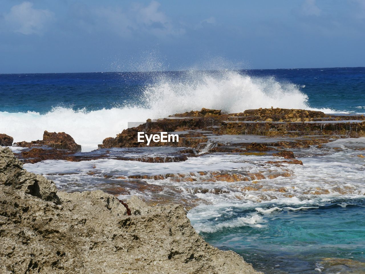 SCENIC VIEW OF WAVES SPLASHING ON ROCKS AT SHORE