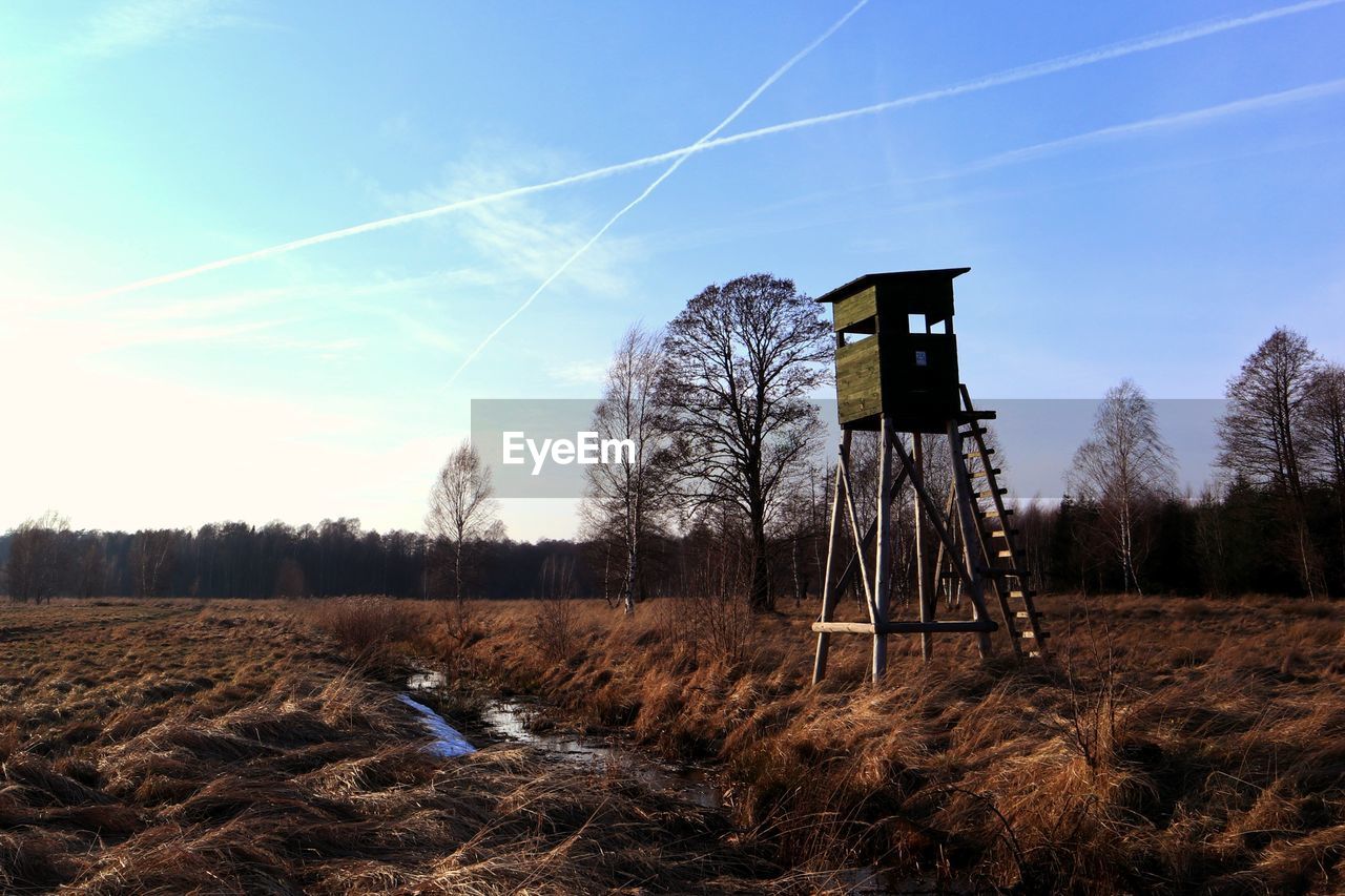 Lifeguard tower on field against sky