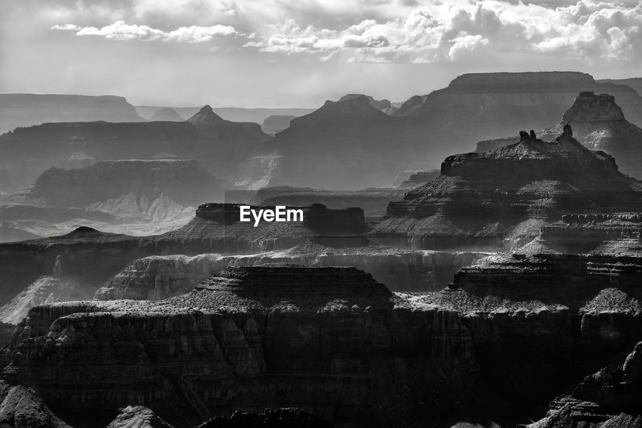 Panoramic view of rocks and mountain against cloudy sky